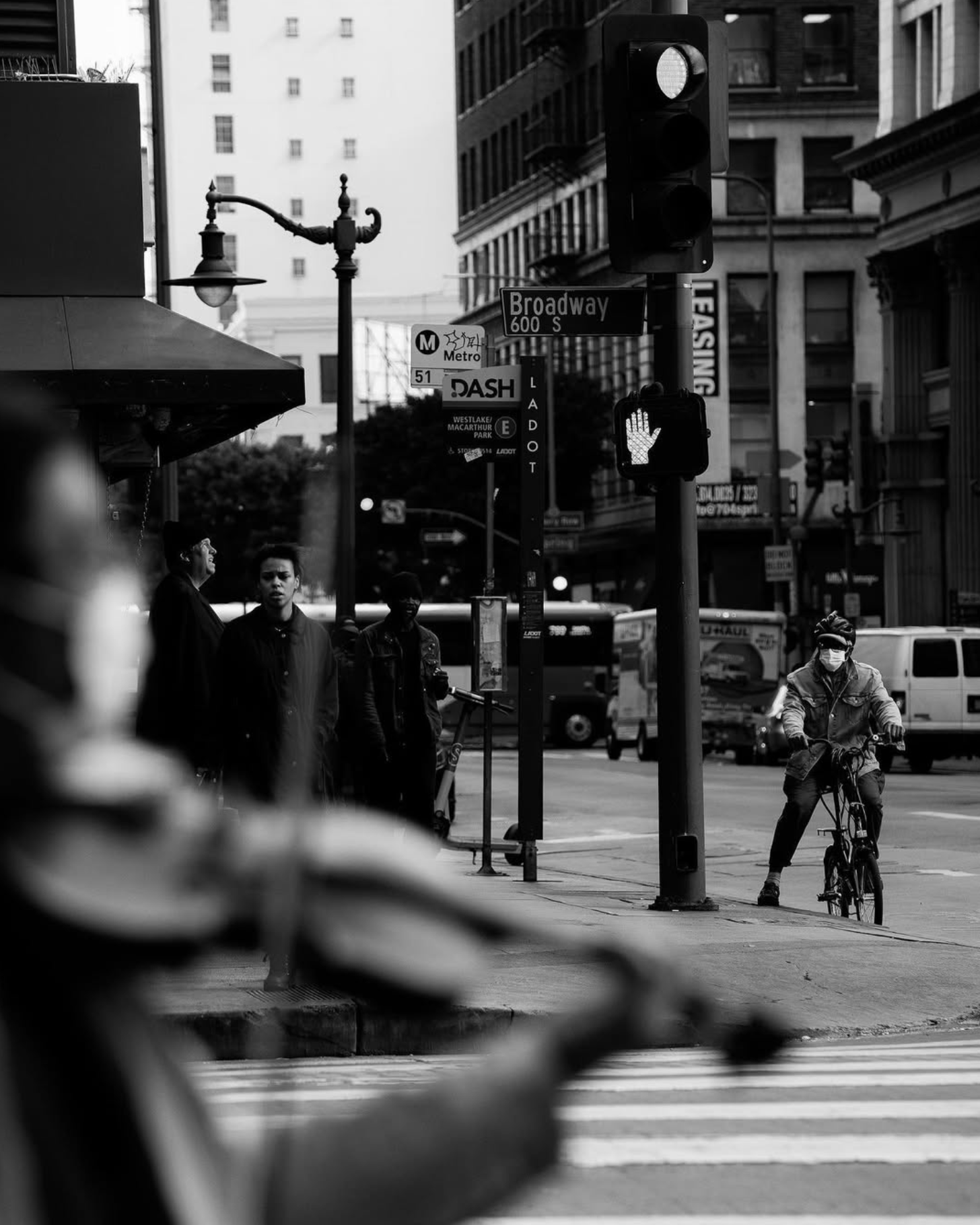 Cyclist and pedestrians waiting at a downtown Los Angeles crosswalk
